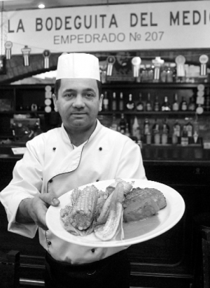 У столичному ресторані ”Ла Бодегіта дель Медіо” кухар Сіро Перес готує свинину зі смаженими бананами. Страва називається ”Чулетос”, коштує 99 гривень