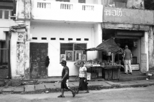 На курорті Бентона на острові Шрі-Ланка працює одна фотостудія (двері ліворуч). На підвіконнях виставлені портрети та весільні фото. Поряд розташований продуктовий магазин. Кілограм яблук коштує від трьох доларів, банани  — 50 центів
