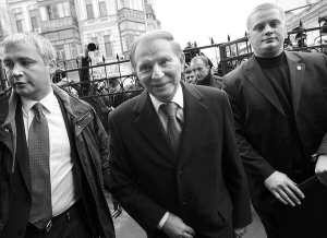 Другий президент Леонід Кучма з двома охоронцями заходить на подвір’я Генпрокуратури. Його викликали 23 березня для допиту по справі з убивства журналіста Георгія Ґонґадзе