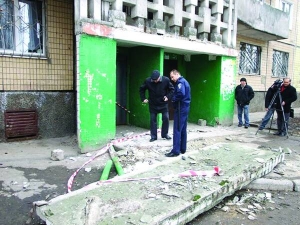 Дільничний (у центрі) оглядає місце на вулиці Кольцова, 5 у Донецьку, де обвалився дах під’їзду. Під плитою загинув чоловік