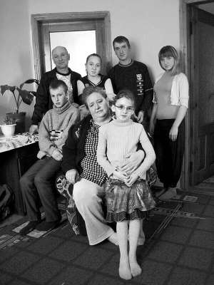 Валентина Паламарчук (сидить у центрі) із села Шарнопіль на Черкащині тримає на колінах 10-річну доньку Олену, поруч сидить син Веніамін, 12 років. У другому ряді зліва направо стоять Григорій, 14-річна Ілона, 16-річний Едуард та Дарина, 15 років. У родин