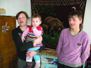 Тетяна Івасюк з донькою Галиною і сином Ігорем у хаті в селі Пахутинці Волочиського району Хмельницької області. Жінка запевняє, що на неї наговорюють