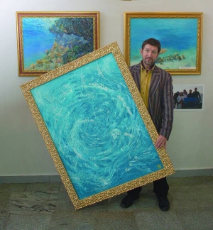Художник Олександр Бєлозор тримає одну зі своїх картин, які показує в Українському домі в Києві