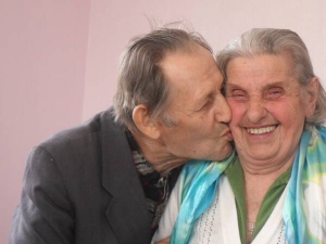 Наталю Білик із селища Ярмолинці на Хмельниччині цілує її сусід і товариш Микола. Жінка поховала сина і чоловіка. Допомагає двом донькам, доглядає четверо онуків і правнука