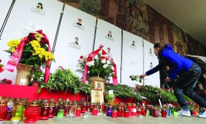 Жінка кладе троянду біля входу на станцію метро Жовтнева у Мінську. Білоруси зносять квіти і запалюють свічки біля метро з вівторка. Під час вибуху там загинули 12 людей
