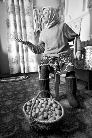 Марія Шовкута з села Нові Опачичі, що у зоні відчуження, показує кошик картоплі, яку відібрала на розсаду. Вирощені овочі дає дітям та онукам