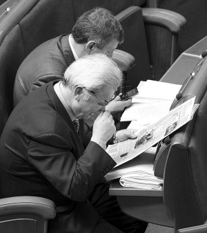 Народний депутат-”нунсівець” Володимир Стретович (на передньому плані) читає газету під час засідання Верховної Ради 19 квітня