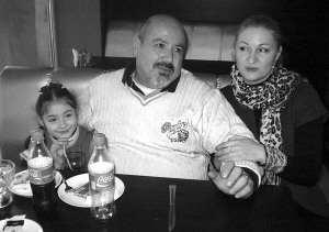 Подружжя Нелі та Рональд Круси з донькою Мішель сидять у кав’ярні міста Калинівка на Вінниччині. Познайомилися в Італії, коли українка гостювала у сестри Наталії