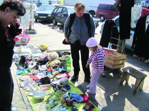 Полтавка з онукою роздивляються товари на блошиному ринку по вулиці Чапаєва. Речі на продаж сюди зносять городяни, частину продавці приносять своїх власних