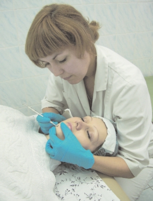 Столичний косметолог Ганна Заглада-Гончарук робить чистку обличчя пацієнтці. Після процедури продезінфікує шкіру і накладе заспокійливу маску