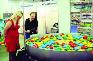 Відвідувачі виставки грального бізнесу в Києві роздивляються автомат ”Пательня із жабами”. Вудкою чоловік намагається спіймати іграшку, в нього не виходить
