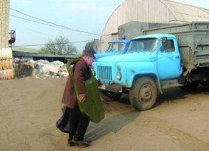 Минулої середи чоловік несе дверцята від вантажівки на пункт прийому металобрухту фірми  ”Вторма” в Умані