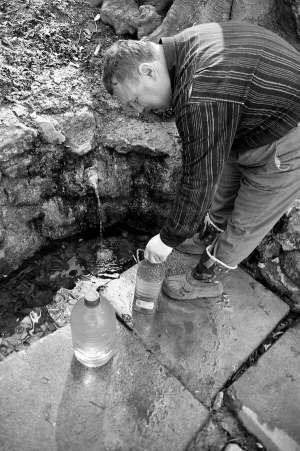 Любомир Мішко набирає воду в бутлі в парку Погулянка у Львові. Щодня після 19.00 до джерела стоїть черга із 10–20 людей