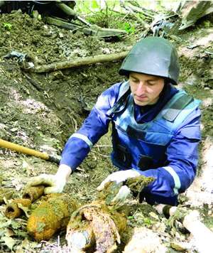 Піротехнік витягує артилерійські снаряди в лісі за райцентром Ярмолинці Хмельницької області. За п’ять днів викопали понад тисячу снарядів