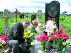 Анатолій і Любов Павлики прибирають могилу племінниці Ярослави Алексеєнко з селища Ромодан Миргородського району Полтавщини. Дівчину вбили 7 травня торік, у день її 15-річчя
