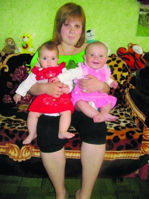 Чернігівка Лілія Павленко в кімнаті гуртожитку з двома п’ятимісячними дівчатами. Праворуч на знімку  її сестра Валерія, ліворуч — дочка Анна