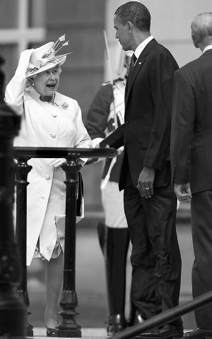 Британська королева Єлизавета ІІ вітається з американським президентом Бараком Обамою перед входом у Букінгемський палац. Правою рукою притримує капелюшок, аби його не зніс вітер