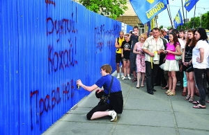 Сергій Марченко пише на будівельному паркані біля Черкаської облдержадміністрації під час акції опозиції 24 травня ”Бунтуй! Кохай! Права не віддавай!”. 1 червня за цей напис Соснівський райсуд Черкас засудив його до арешту