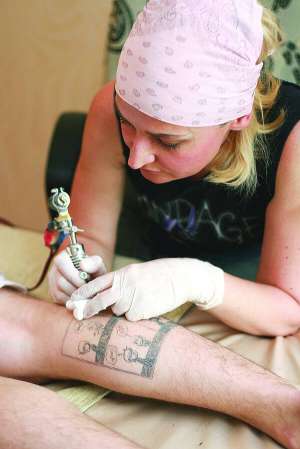 Світлана Ксенжук робить корекцію татуювання на литці клієнта. Радить, перш ніж зробити тату, знайти ”свого” майстра. Працює у цій сфері 11 років