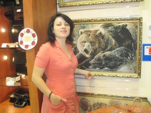 Директор вінницького магазину ”Глазур” Наталія Коломієць показує фабричний гобелен з ведмедями. Такий коштує близько 400 гривень. Їх купують часто