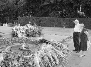 Жінка та чоловік стоять біля Вічного вогню у столичному Парку Слави о 19.30 22 червня. Після того, як у понеділок на ньому посмажили яєчню, постійної охорони там не поставили. Патруль проходить повз кожні 40–50 хвилин