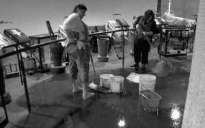 Працівниці меморіалу Голодомору в понеділок швабрами збирають дощову воду, що ллється зі стелі. Через дощі в музеї затопило виставкову залу