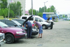 На автостоянці на вулиці Тараскова в Черкасах чоловіки ремонтують машини.  29 червня їх залило водою по вікна.  У більшості автівок  повиходило з ладу електрообладнання 