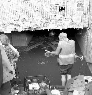 Продавці стоять при вході до підземного переходу біля столичного метро Шулявська у середу. Через зливу їхні місця всередині залило водою