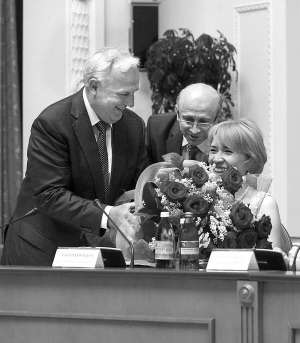 На засіданні уряду 13 липня міністр регіонбуду Анатолій Близнюк (ліворуч) кладе на робочий стіл букет, подарований йому першим віце-прем’єром Андрієм Клюєвим 