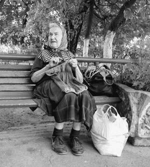 Киянка Марія Голуб в’яже жилетку в парку біля станції метро Політехнічний інститут.  Живе неподалік в однокімнатній квартирі