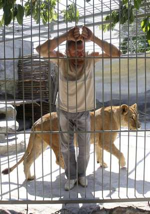 Художник Олександр Пилишенко стоїть у вольєрі з левицею. Тримає її на подвір’ї свого будинку. У його міні-зоопарку є ще два леви, ведмідь, пара рисей, три собаки. Доки житиме з твариною, буде малювати