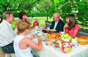 Прем’єр-міністр Микола Азаров п’є чай в гостях у Валентини Горик (ліворуч) із селища Сутиски на Вінниччині. Поруч сидять онука Юлія (справа),  онук Андрій і Костянтин Васильович, чоловік Валентини