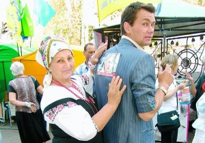 Киянка Людмила Литвин розгладжує наклейку із зображенням Юлії Тимошенко на спині Мирослава Набиля під час мітингу на підтримку екс-прем’єрки на Хрещатику