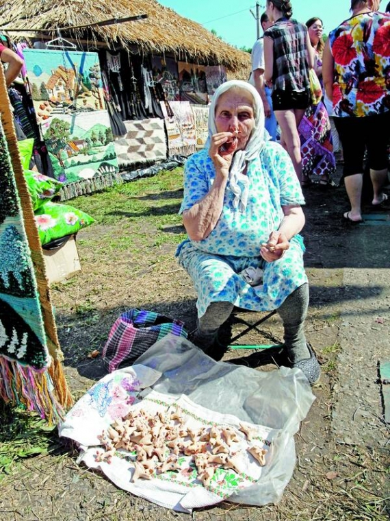 Пенсіонерка з Опішні біля центрального входу торгує глиняними свистульками. Удома їх ліпить разом із чоловіком