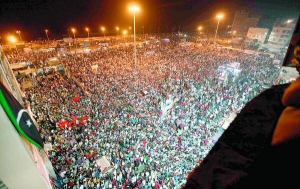 Тисячі людей зібралися біля будівлі суду в лівійському місті Бенгазі 22 серпня 2011 року. Вони святкують захоплення столиці Триполі опозиційними силами, які вимагають відставки лідера країни Муаммара Каддафі