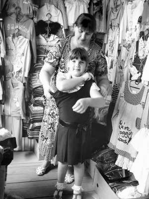 На ринку райцентру Калинівка першокласниця Анна Лукашук з матір’ю Наталією міряє шкільний сарафан за 90 гривень. Блузку та гольф віддають за 75 і 90 гривень 