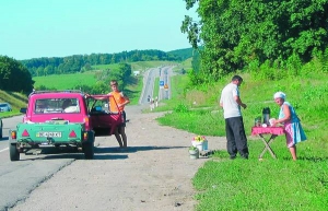 Жінка продає каву із розкладного столика на 144-му кілометрі траси Київ–Одеса поблизу Жашкова. Раніше уздовж дороги стояли торговельні намети та кіоски