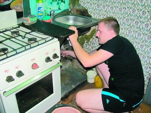 Полтавчанин Іван Срібний ремонтує каналізаційну трубу на кухні. Її не міняли понад 25 років