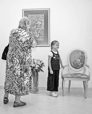 Літня жінка з дівчинкою розглядають картину та стілець із вишивкою у столичному Центрі культури та мистецтв 3 вересня. Того дня його відкрили у новому приміщенні на вулиці Хорива, 19в