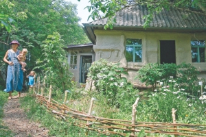 Хата екопоселенців Ольги та Петра Раєвських на околиці села Ромашки Миронівського району на Київщині. Вони ходять босоніж, в озері купаються голяка, сплять на вулиці та не полють бур’яни на городі. У Ромашки сім’я переїхала вісім років тому