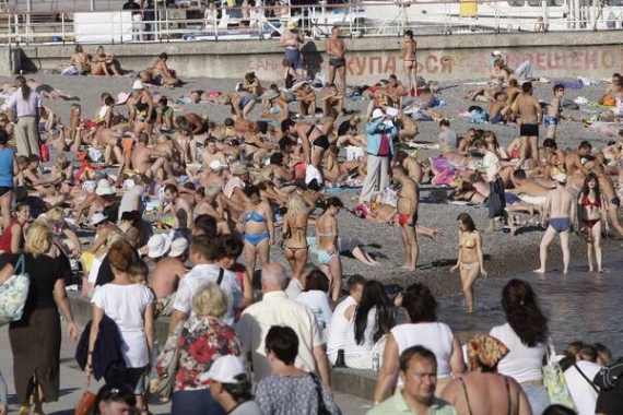 Туристи засмагають на пляжі ”Приморський” у Ялті. Температура повітря +25°С. Температура води +20°С