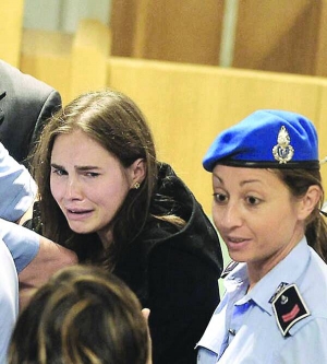 Аманда Нокс плаче, оточена конвоєм у залі суду Перуджі, Італія, після того як журі присяжних визнало її та хлопця невинними у вбивстві та зґвалтуванні британської студентки Мередіт Керчер