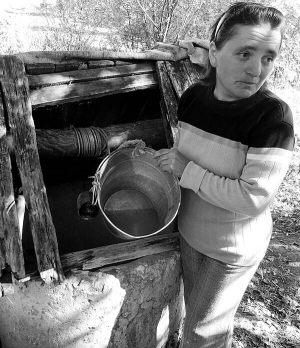 Марія Муравська із села Уритва Козівського району Тернопільщини показує воду, яку набрала з дна криниці. Вона брудна, з глиною