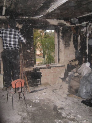 Микола Габор збиває штукатурку, вкриту сажею, у кімнаті, з якої почав горіти гуртожиток на вулиці Курчатова в Полтаві