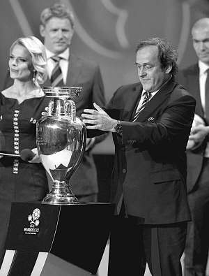 Президент УЄФА Мішель Платіні з кубком, який вручається чемпіону Європи.  У 2000-му французи, святкуючи успіх, розбили трофей прямо на полі