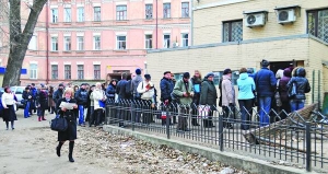 У вівторок, 6 грудня, в черзі до Центрального бюро технічної інвентаризації Києва на вулиці Трьохсвятительській чекають понад 60 осіб. Дехто, щоби згаяти час, читає книжку