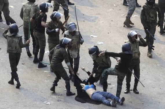 Єгипетські солдати б’ють жінку, намагаючись заарештувати її, у суботу на площі Тахрір у столиці Єгипту Каїр. Демонстранти вимагають відставки військового правління країни. Під час заворушень, що спалахнули у п’ятницю, загинули щонайменше 15 людей