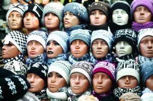 Манекени з шапками стоять на прилавку на Краківському базарі у Львові. Їх продають за 70-100 гривень