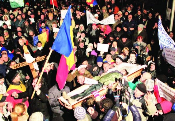 Демонстранти несуть символічну труну президента Румунії Траяна Басеску під час антиурядових протестів у столиці країни Бухарест у понеділок