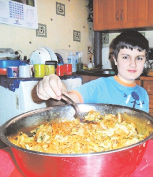 Киянин 12-річний Микита Розводовський куштує салат зі свинячих вух. Страву приготувала баба на Різдво